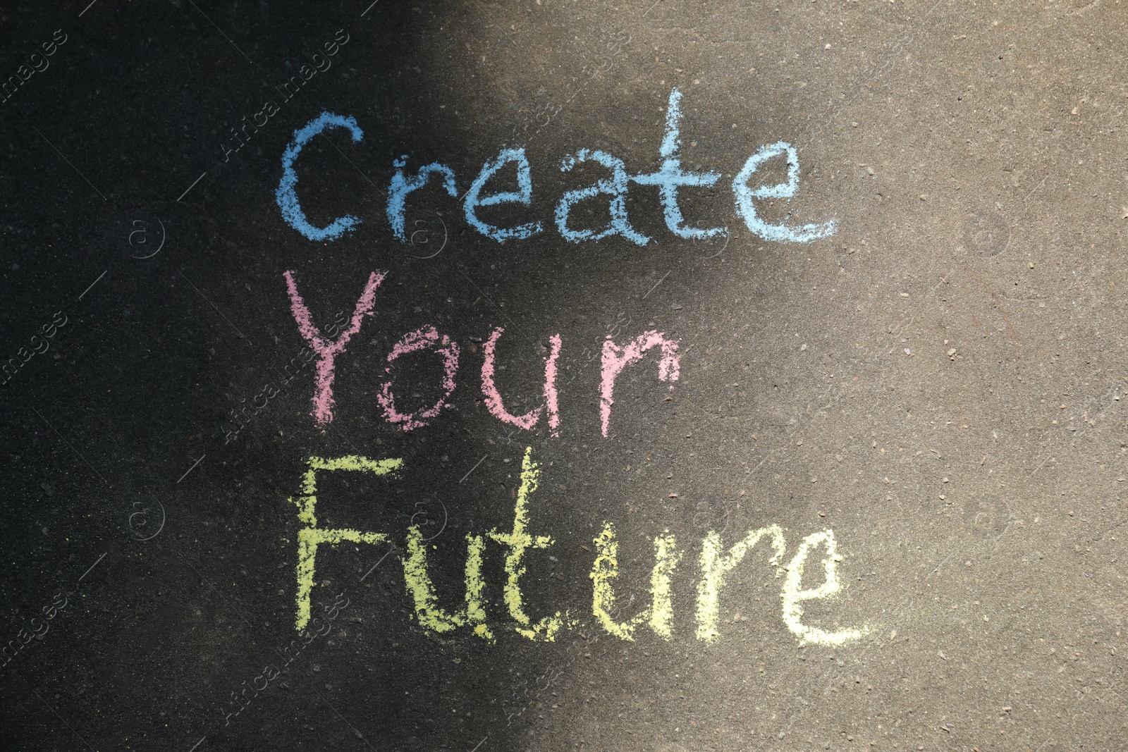Photo of Phrase Create Your Future written on asphalt, top view