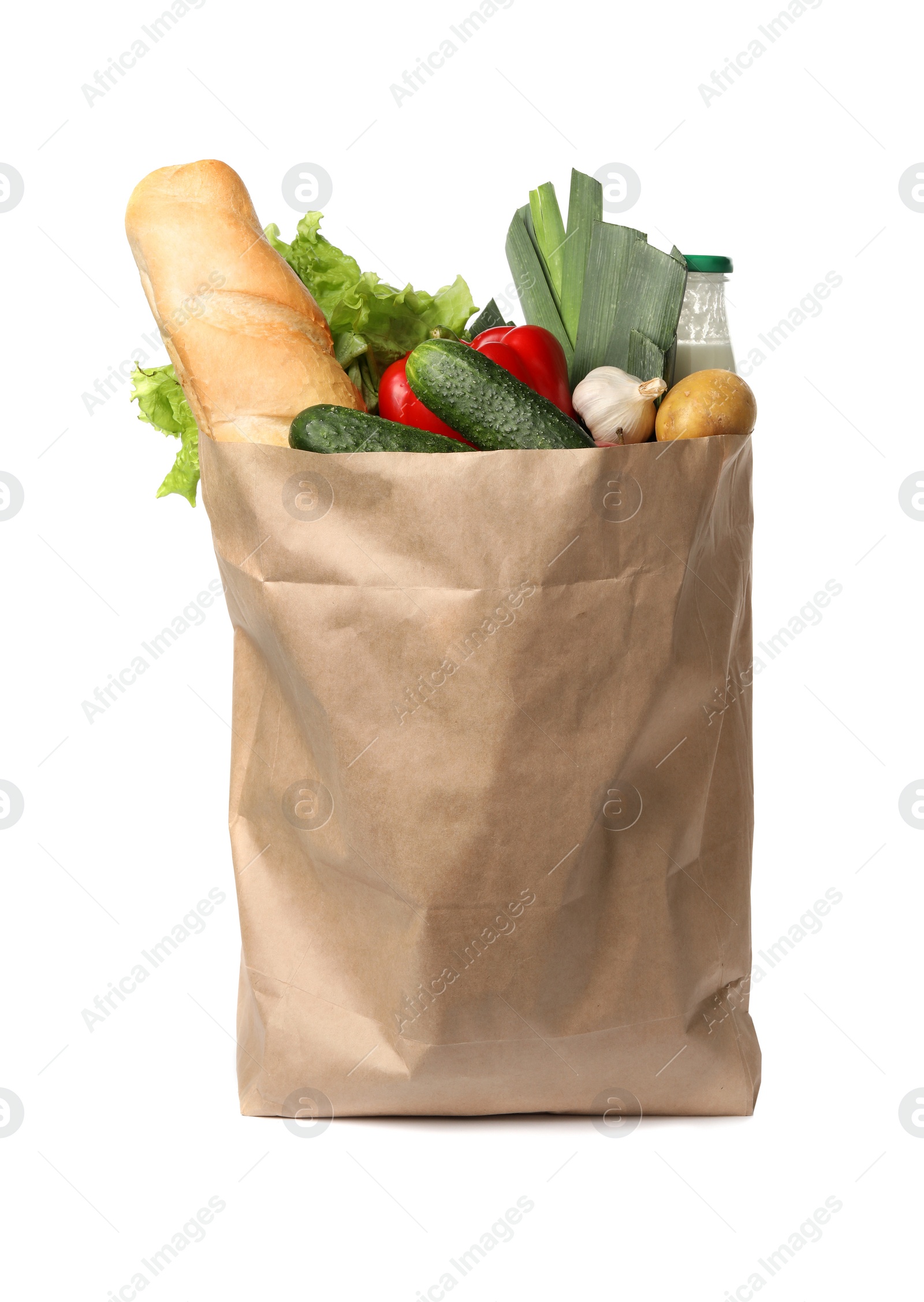 Photo of Paper bag with fresh vegetables and bread on white background