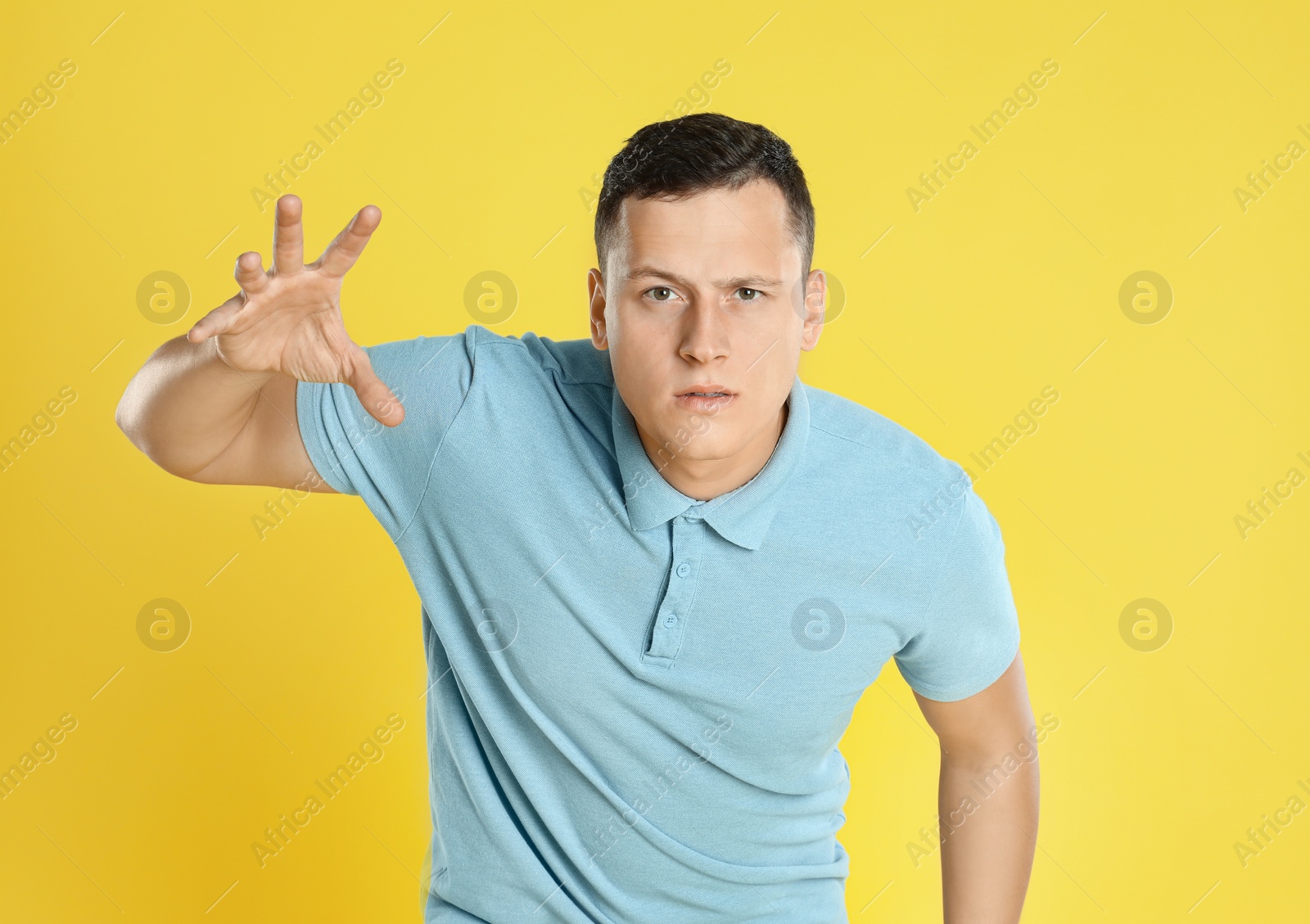 Photo of Grumpy young man posing on yellow background