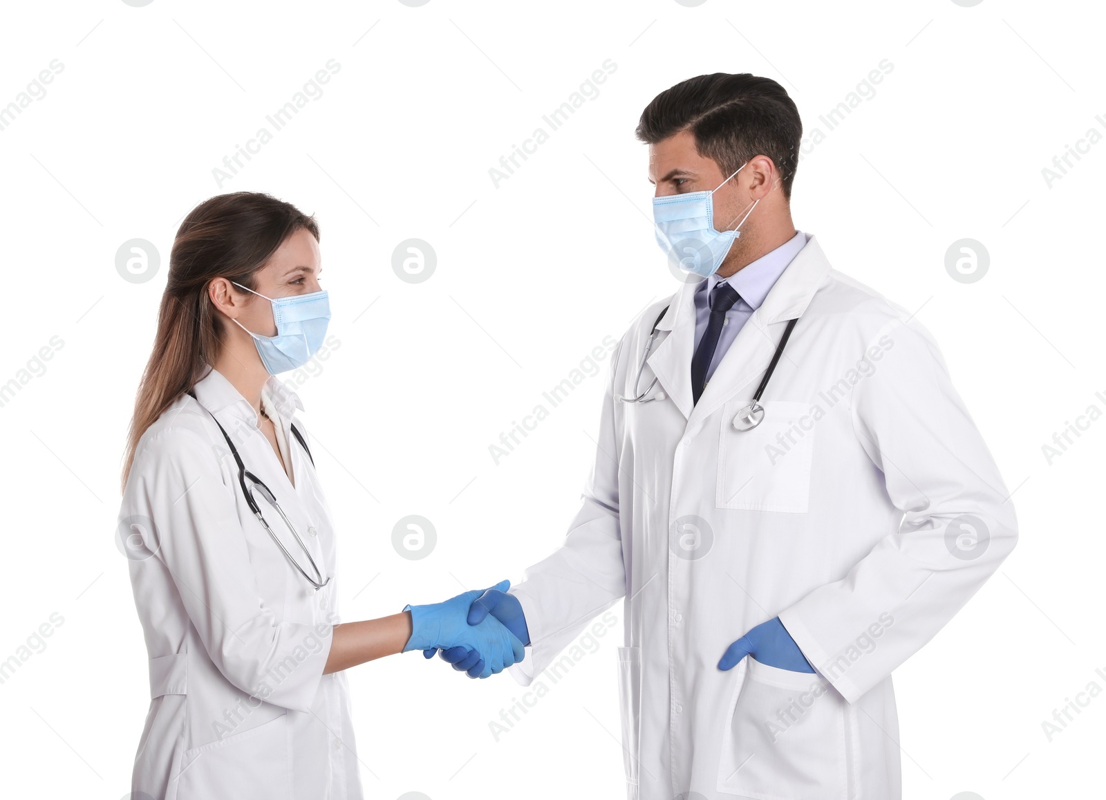 Photo of Doctors in medical face masks shaking hands on white background