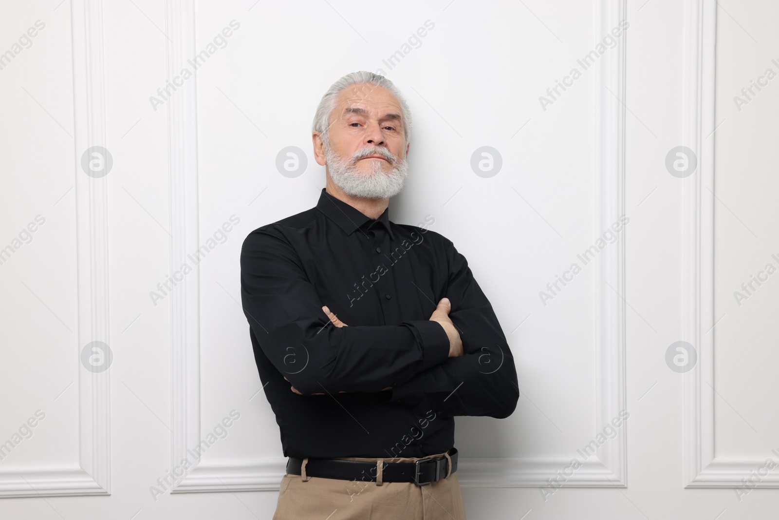 Photo of Portrait of handsome senior man near white wall