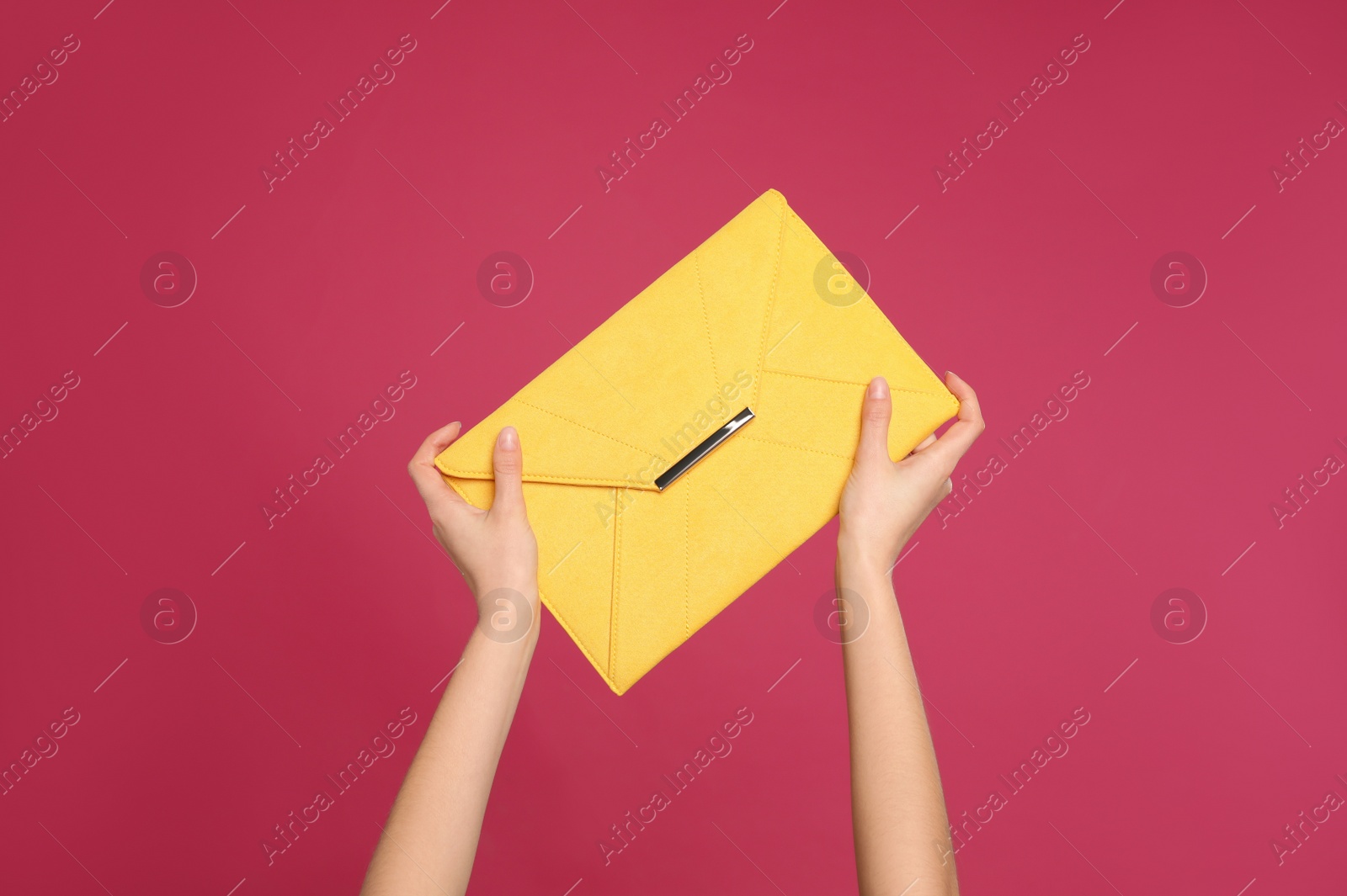 Photo of Woman holding stylish envelope bag on pink background, closeup