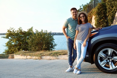 Photo of Happy young couple near family car on riverside