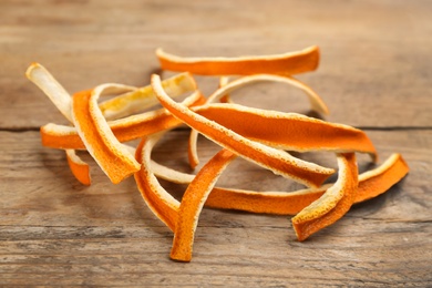 Photo of Pile of dry orange peels on wooden table