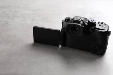 Modern camera on light grey stone table. Video production industry