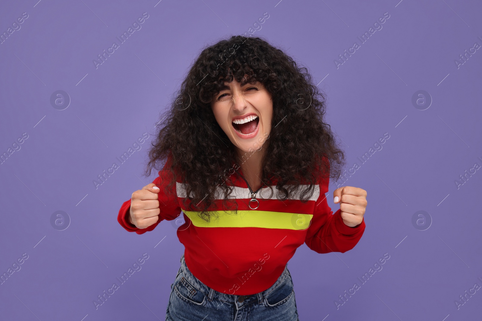 Photo of Happy sports fan celebrating on violet background