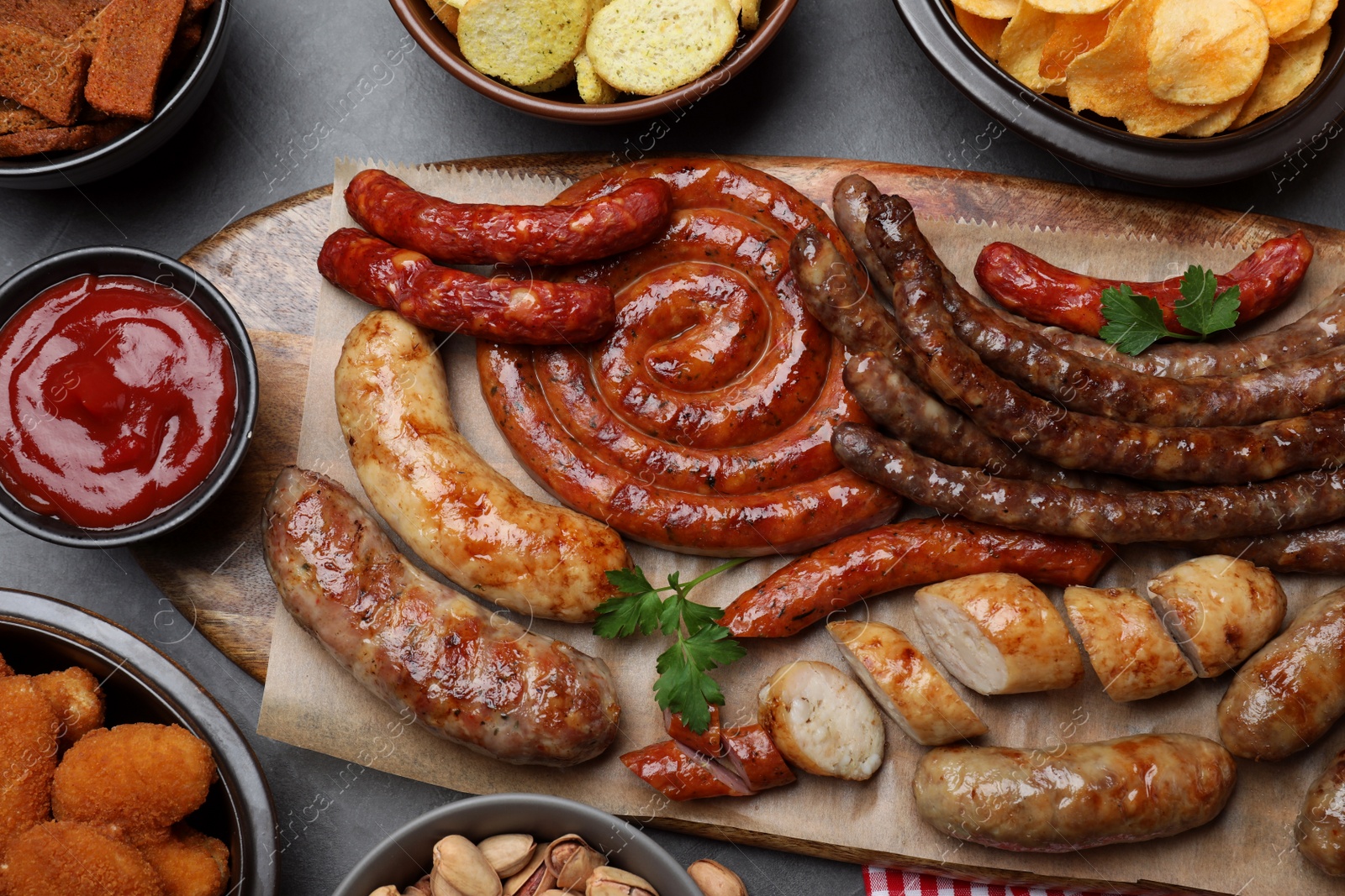 Photo of Set of different tasty snacks on dark grey table, flat lay