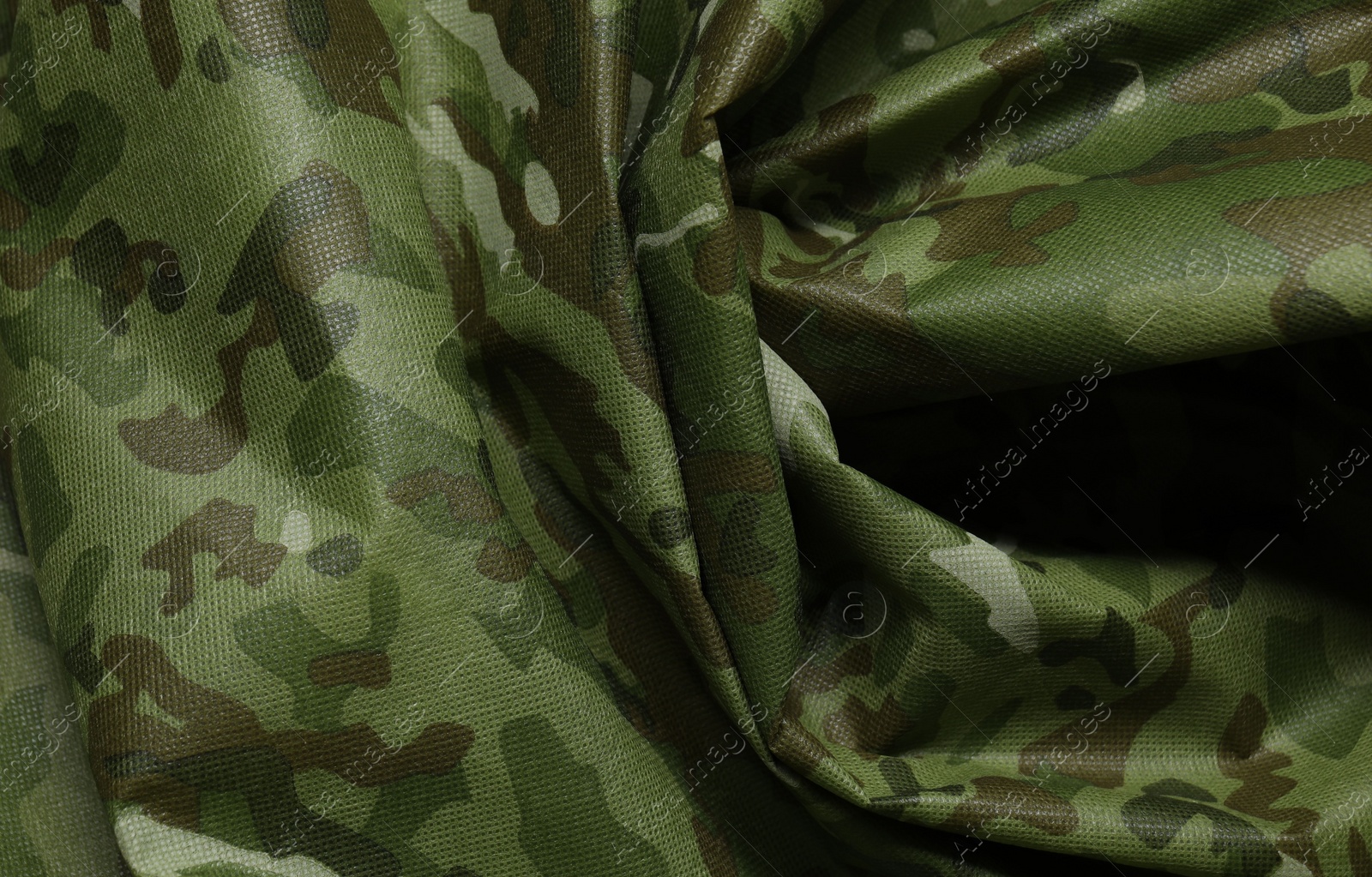 Photo of Texture of crumpled camouflage fabric as background, top view