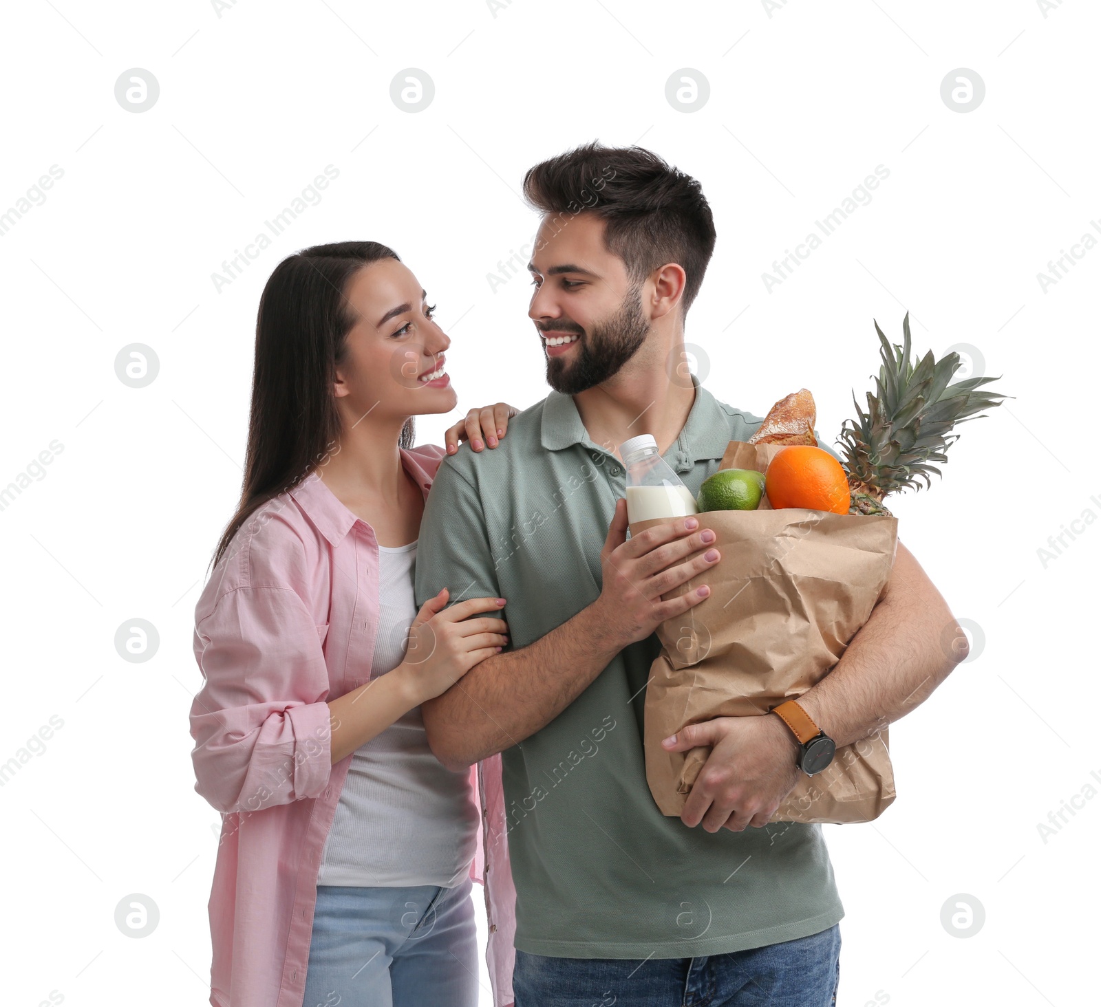 Photo of Young couple with groceries on white background