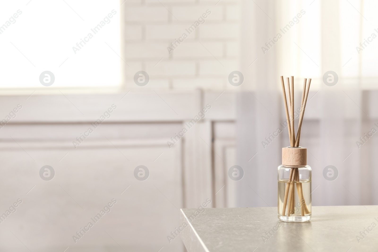 Photo of Reed air freshener on table indoors, space for text