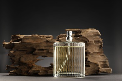 Photo of Luxury men`s perfume in bottle on grey table