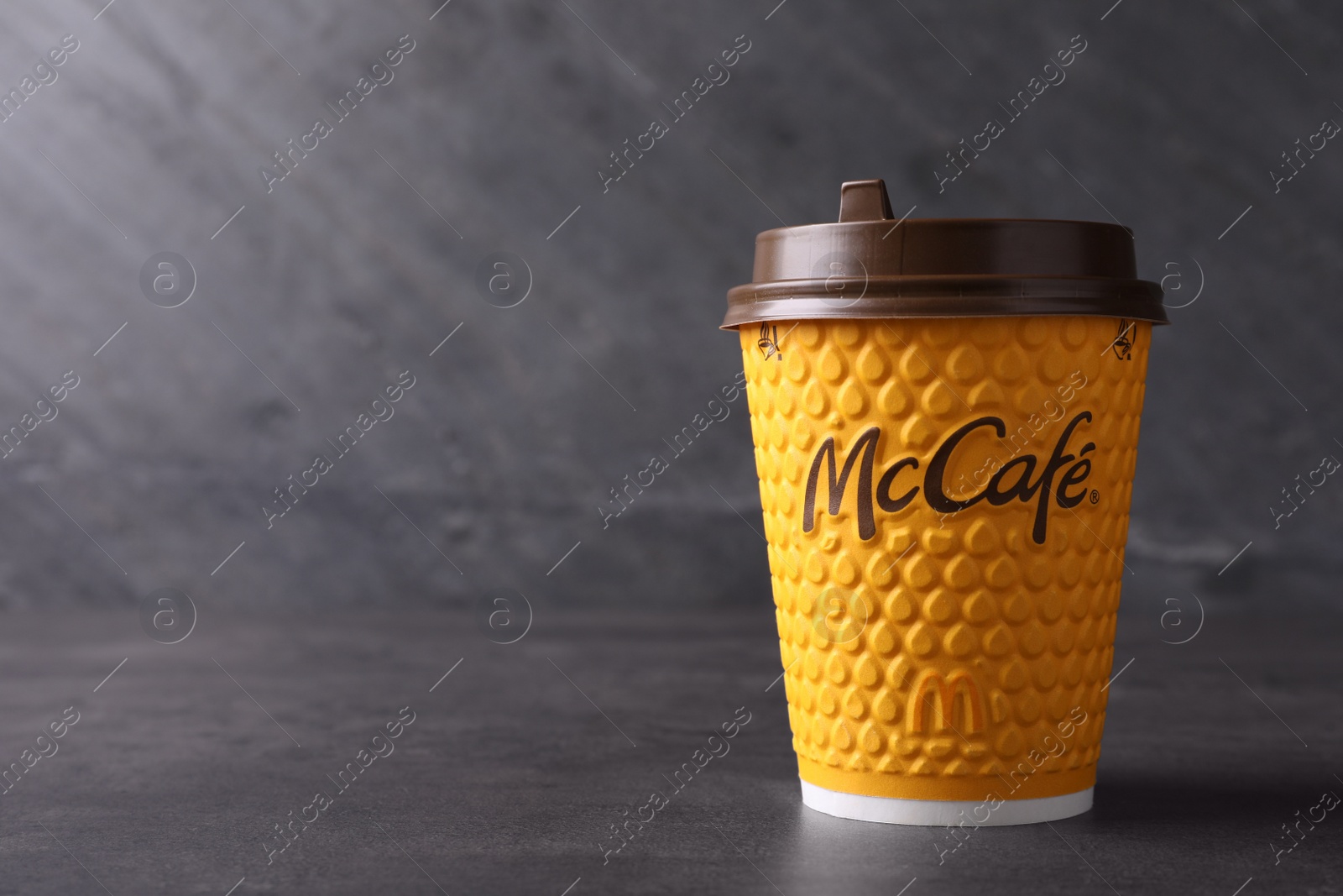 Photo of MYKOLAIV, UKRAINE - AUGUST 12, 2021: Hot McDonald's drink on grey table. Space for text