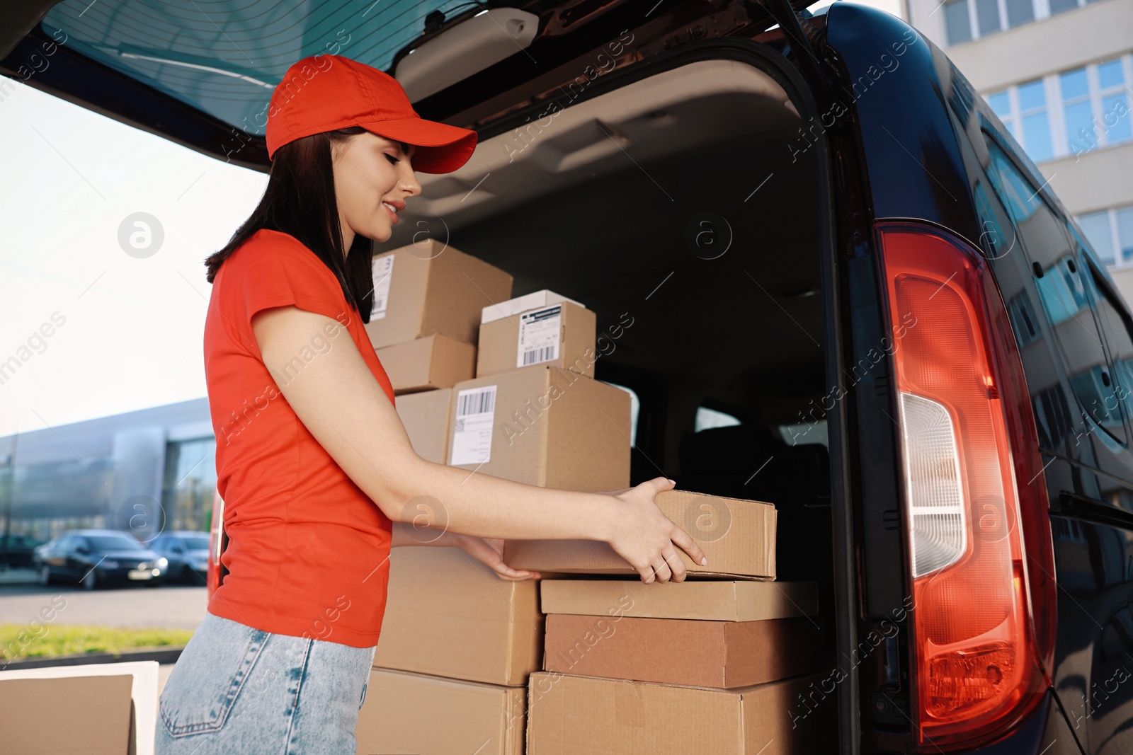 Photo of Courier taking parcel from delivery van outdoors