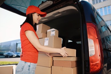 Courier taking parcel from delivery van outdoors