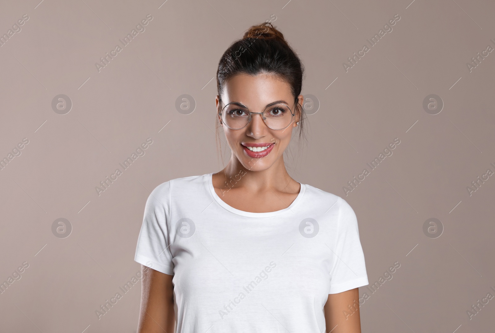 Photo of Beautiful woman in eyeglasses on light brown background