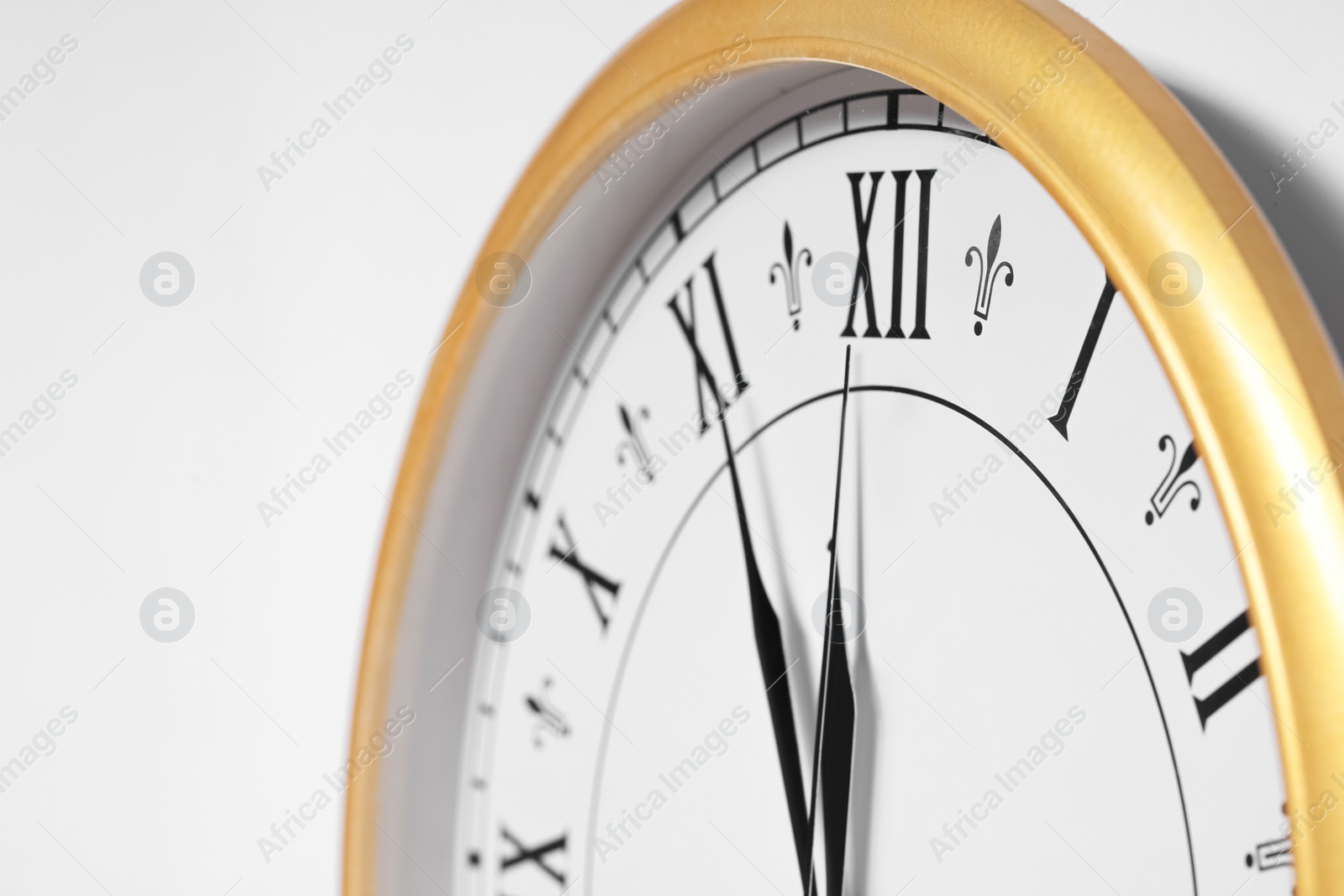 Photo of Clock showing five minutes until midnight on white background, closeup. New Year countdown