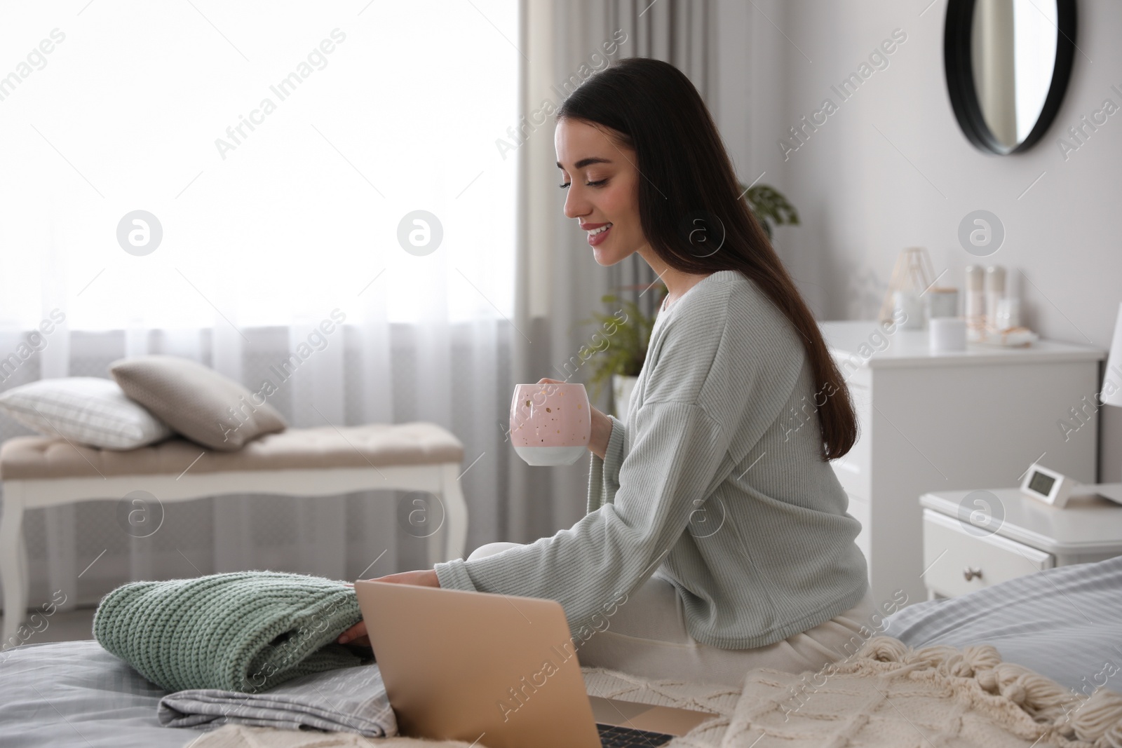 Photo of Young woman choosing clothes for work day at home. Morning routine