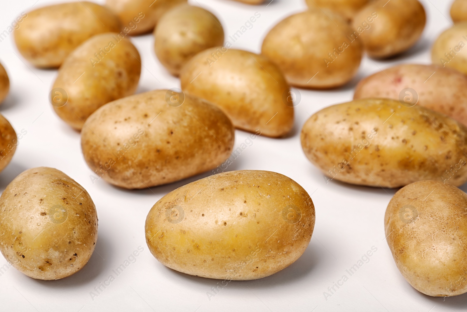 Photo of Fresh organic potatoes on white background, closeup view