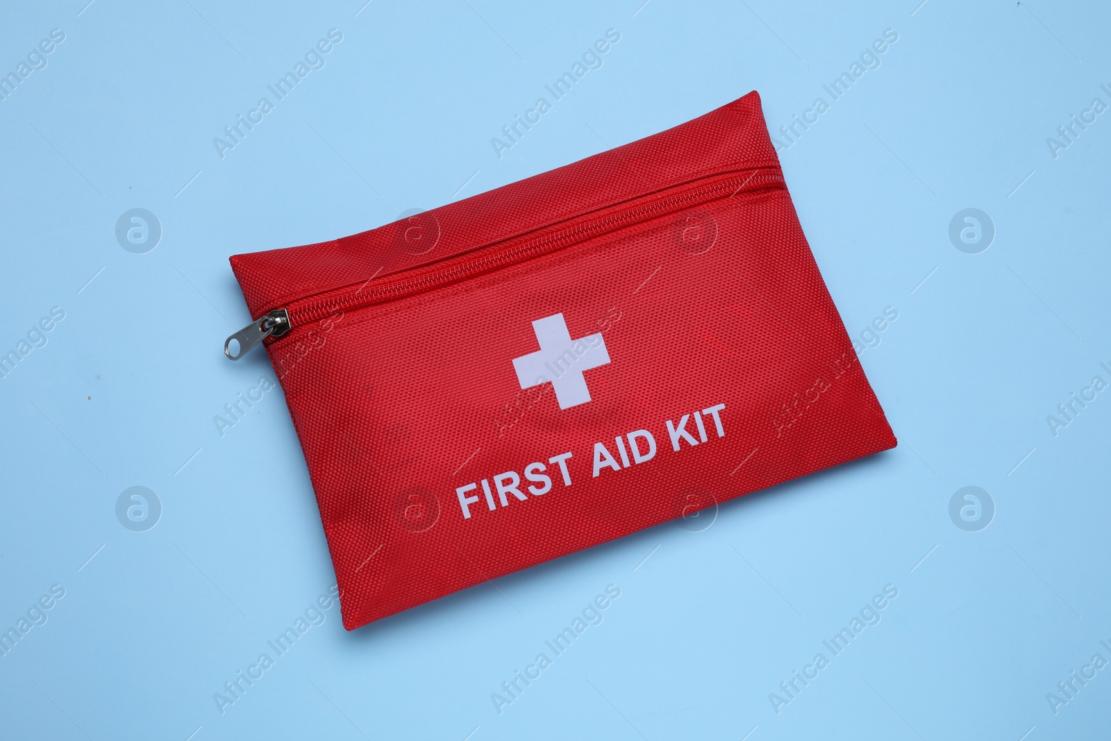 Photo of First aid kit on light blue background, top view