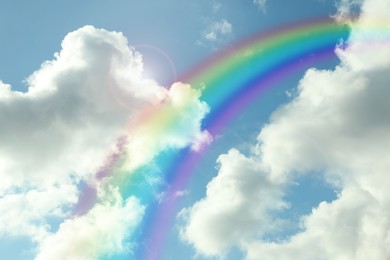 Image of Beautiful view of bright rainbow in blue sky on sunny day