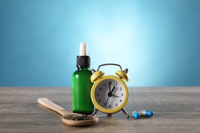 Photo of Alarm clock and insomnia remedies on wooden table