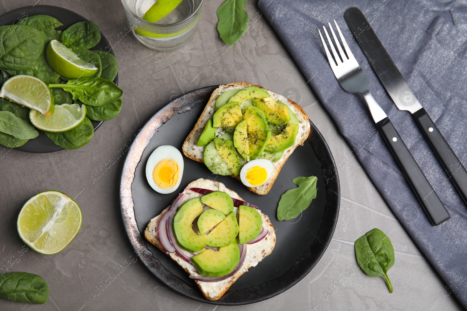 Photo of Flat lay composition with avocado toasts on grey table