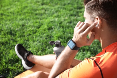 Photo of Man with fitness tracker after training in park, closeup