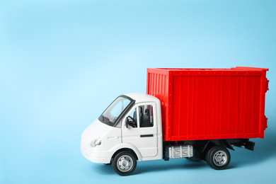 Photo of Toy truck on blue background, space for text. Logistics and wholesale concept