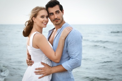 Happy young couple spending time at sea beach