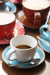 Photo of Cups of fresh aromatic coffee on wooden table