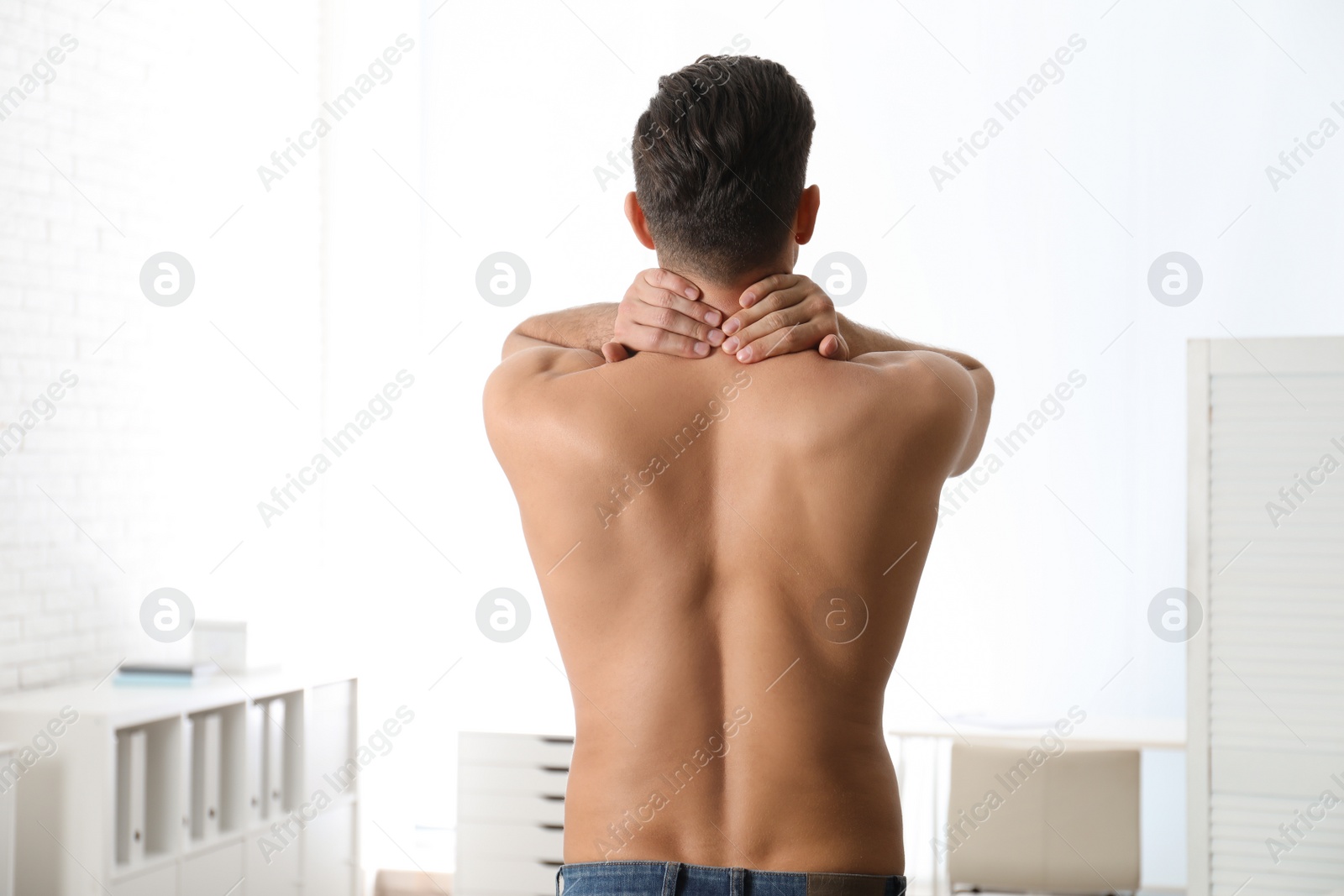 Photo of Man suffering from pain in neck at clinic. Visiting orthopedist