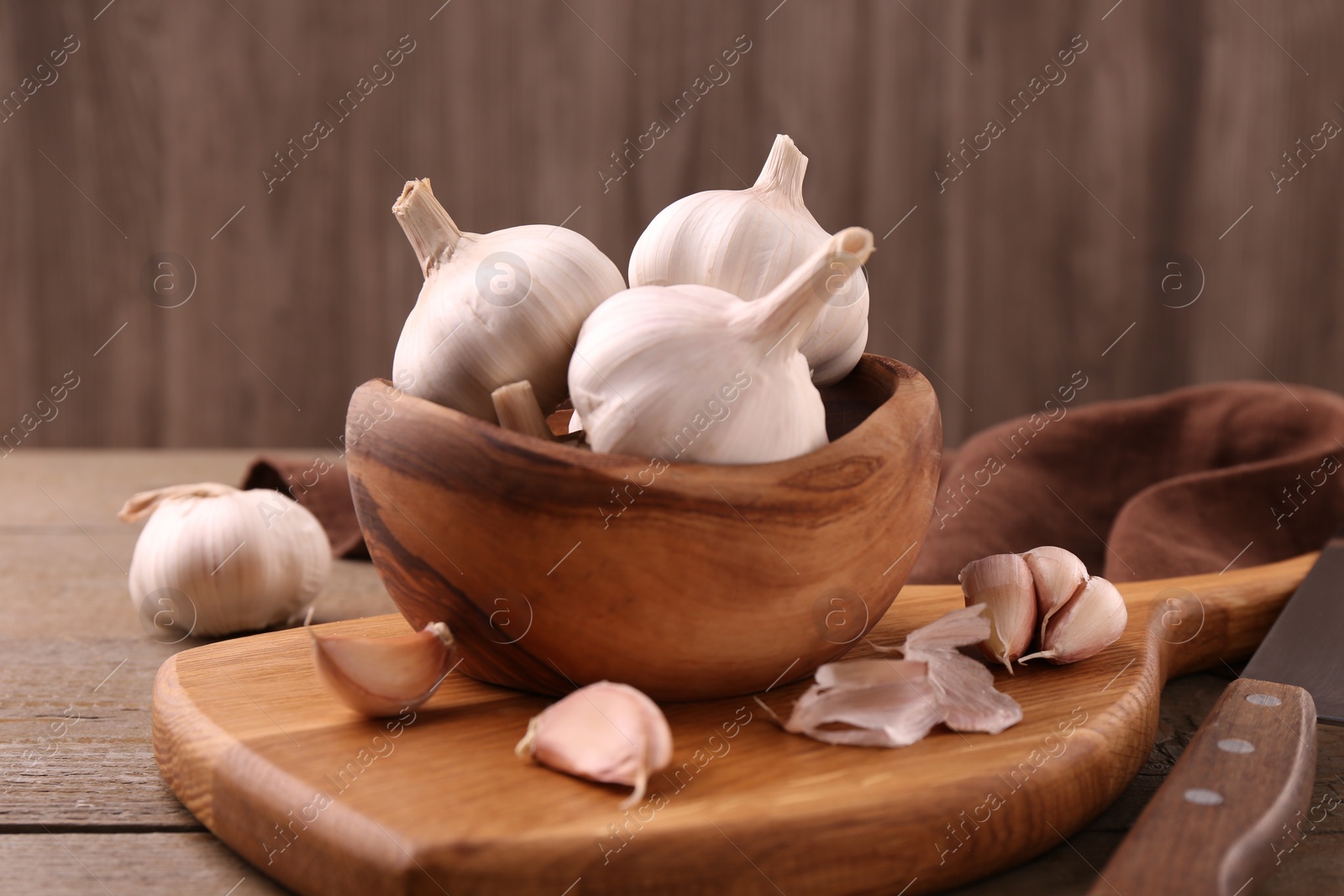 Photo of Fresh garlic and knife on wooden table, closeup