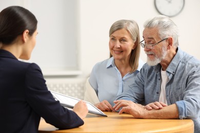 Notary consulting senior couple about Last Will and Testament in office