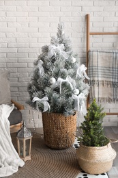 Stylish interior with beautiful Christmas tree near white brick wall