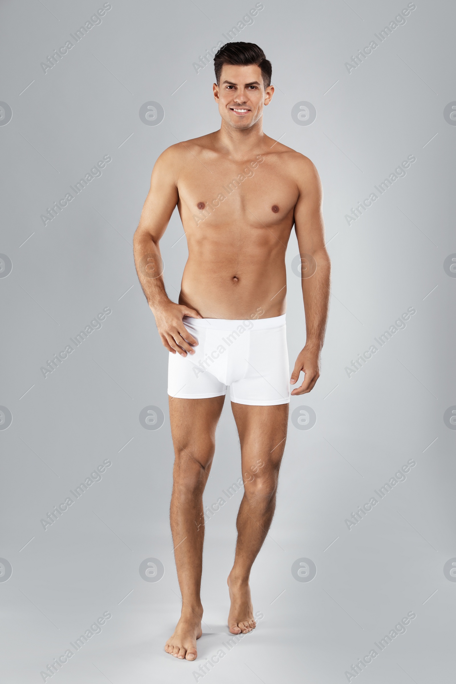 Photo of Handsome man in white underwear on light grey background