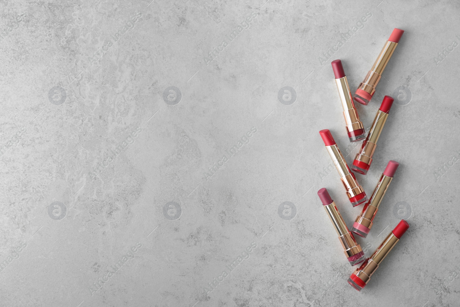 Photo of Set of bright lipsticks on grey background, flat lay. Space for text