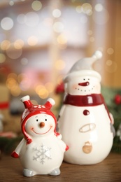 Photo of Decorative snowmen on wooden table, space for text