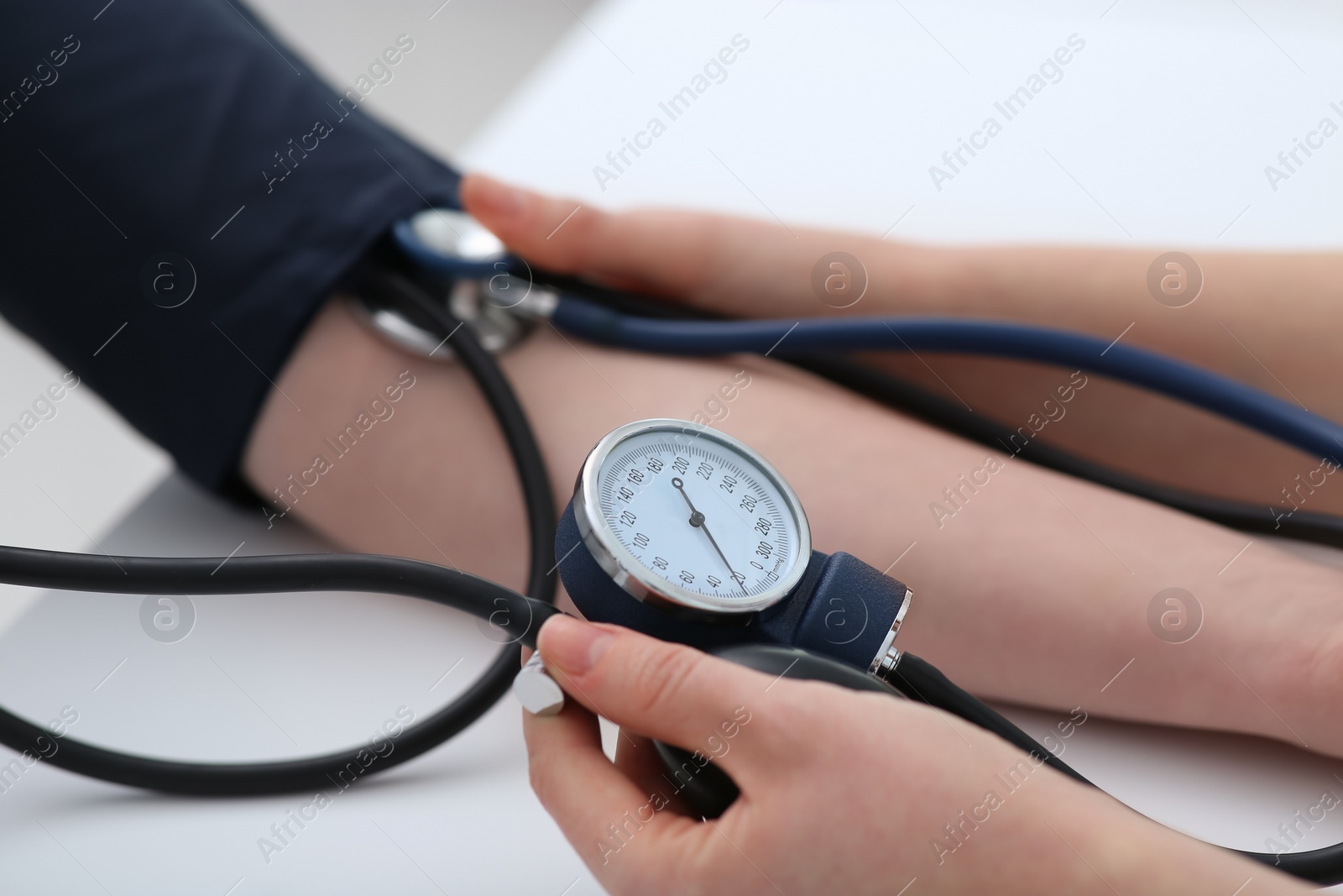 Photo of Doctor checking blood pressure of woman in clinic, closeup