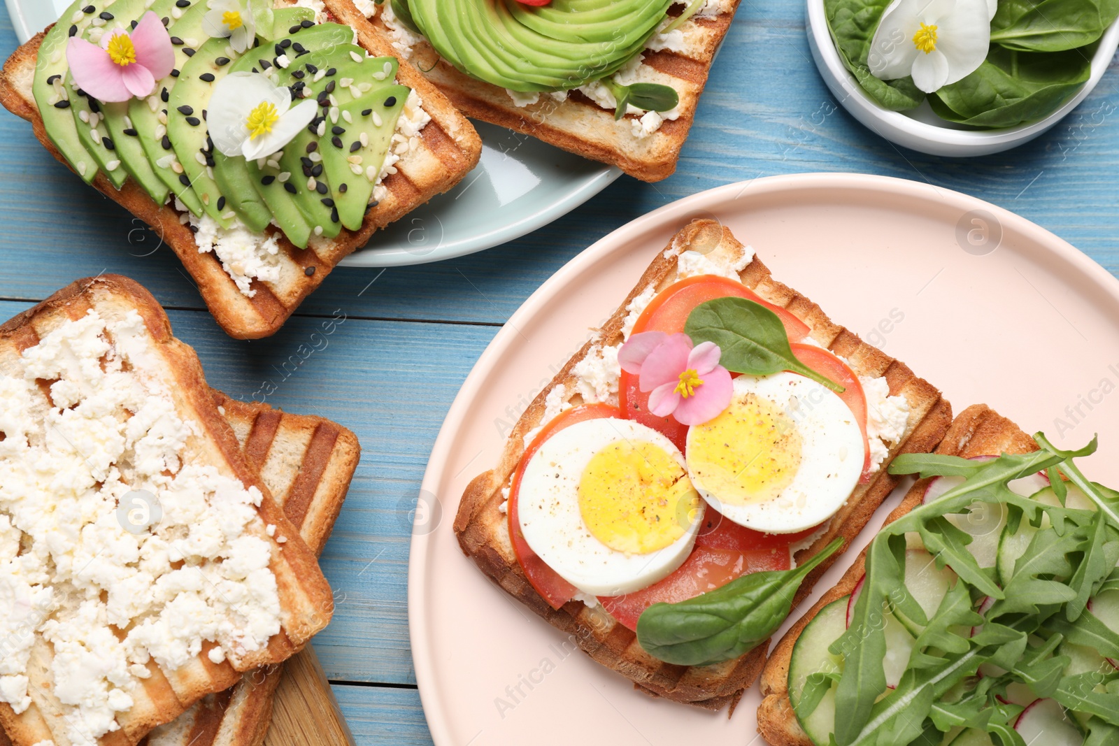 Photo of Different delicious sandwiches on light blue wooden table, flat lay