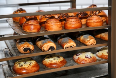 Rack with fresh pastries in bakery workshop