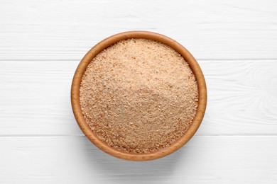 Photo of Fresh breadcrumbs in bowl on white wooden table, top view