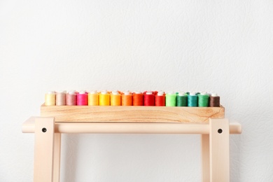 Wooden box with color sewing threads on table