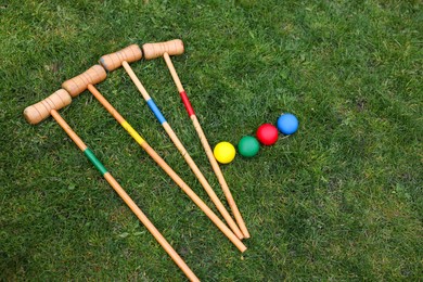 Set of croquet equipment on green grass, above view