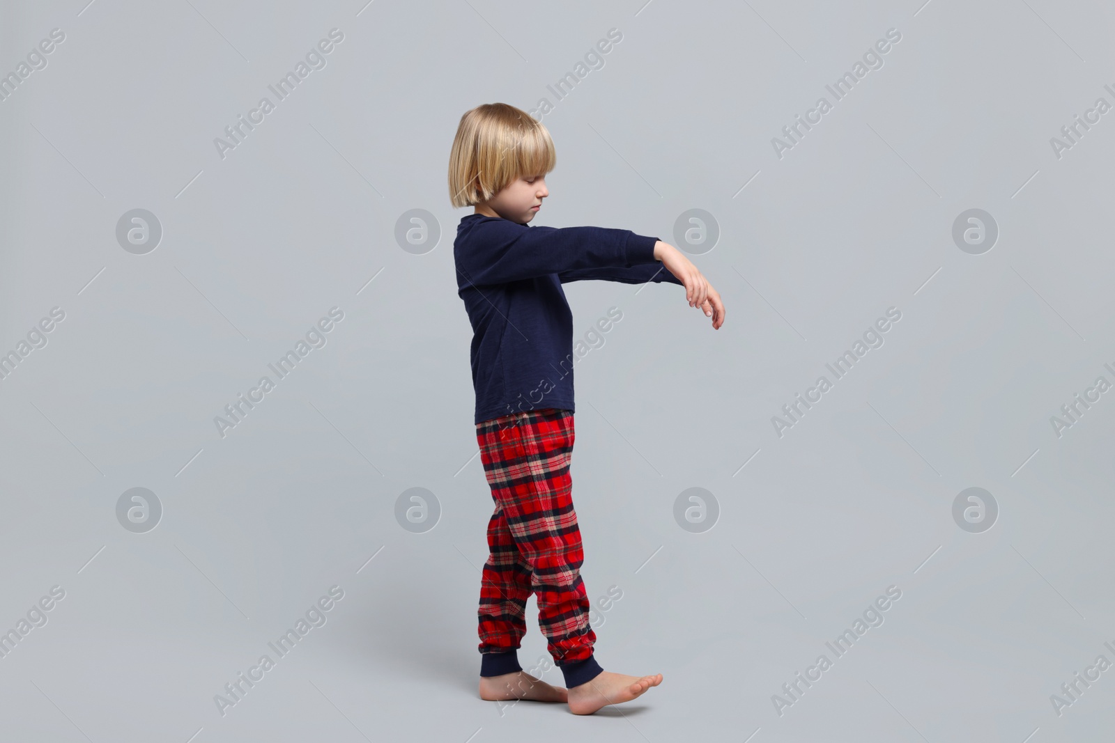 Photo of Boy in pajamas sleepwalking on light gray background