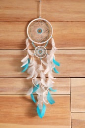 Photo of Beautiful dream catcher hanging on wooden wall