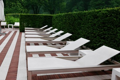 Photo of Many empty sunbeds outdoors on summer day