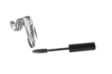 Photo of Smear of mascara and applicator isolated on white, top view