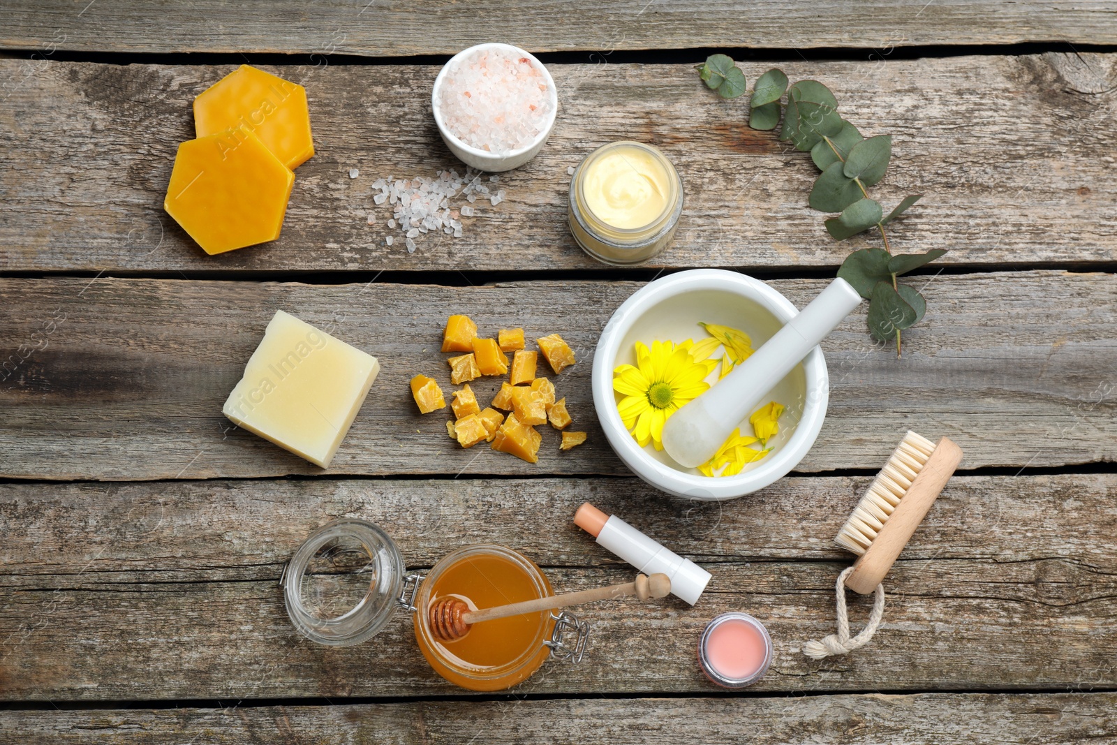 Photo of Flat lay composition with beeswax and cosmetic products on wooden table