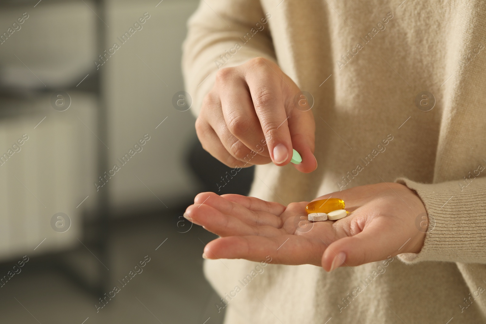 Photo of Young woman with dietary supplement pills indoors, closeup. Space for text