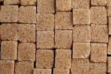 Photo of Brown sugar cubes as background, top view